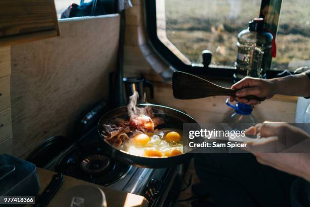 cooking eggs and bacon in skillet at campsite - camping stove stock pictures, royalty-free photos & images
