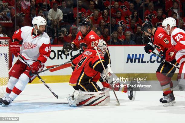 Miikka Kiprusoff makes a save as Cory Sarich and Mark Giordano of the Calgary Flames skate against Todd Bertuzzi and Jason Williams of the Detroit...