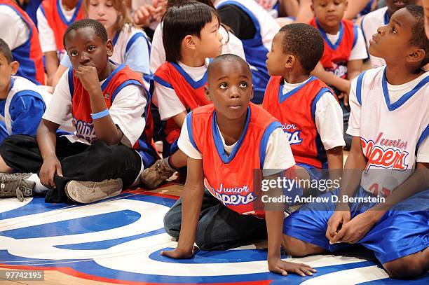 Participants sit on the baseline during a Los Angeles Clippers pregame clinic with 100 winners of the Jr. Clippers Essay and Sportsmanship Contest at...