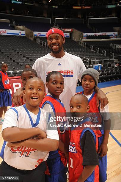 Children pose with Bobby Brown of the Los Angeles Clippers during a pregame clinic for 100 winners of the Jr. Clippers Essay and Sportsmanship...