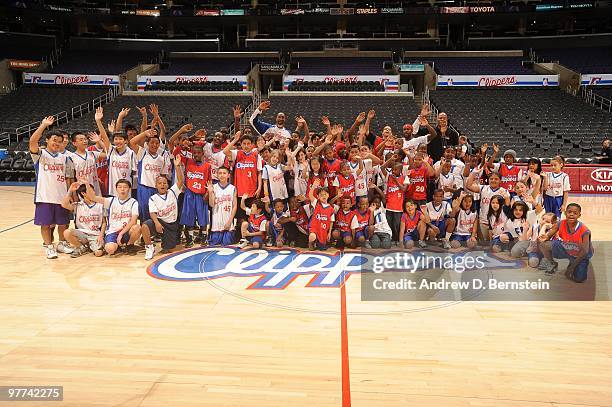 Former Los Angeles Clipper Sean Rooks and current Clipper players Bobby Brown and Brian Skinner pose for a photograph during a pregame clinic with...