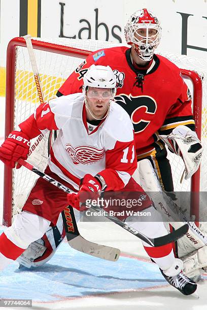 Miikka Kiprusoff of the Calgary Flames defends against Daniel Cleary of the Detroit Red Wings in the crease on March 15, 2010 at Pengrowth Saddledome...