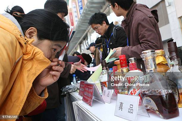 Customers learn to distinguish alcohol products from the fake ones during an event held by the General Administration of Quality Supervision,...