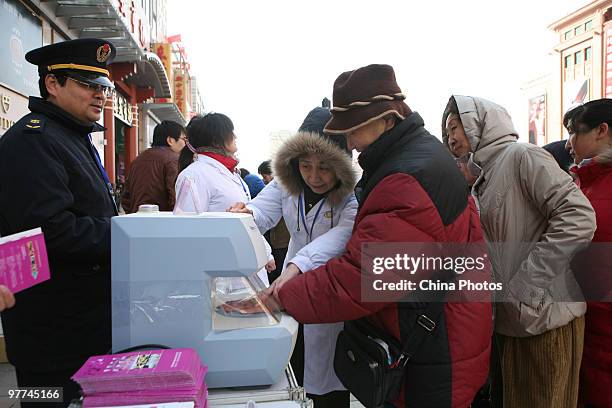 Staffs with the General Administration of Quality Supervision, Inspection and Quarantine examine bone density for customers with an apparatus, during...