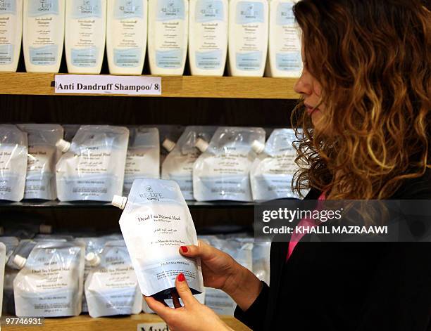 Saleswoman holds a package of Dead Sea mineral mud at a shop in the Jordanian capital Amman on March 15, 2010. Jordan seeks to compete with...