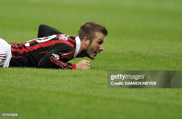 Milan's English midfielder David Beckham lays on the pitch during his team's Italian Serie A football match against Chievo on March 14, 2010 at San...
