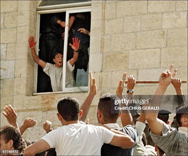 Palestinian youth proudly shows Israeli blood on his hands as he is cheered by fellow protesters at a Palestinian police station in the West bank...