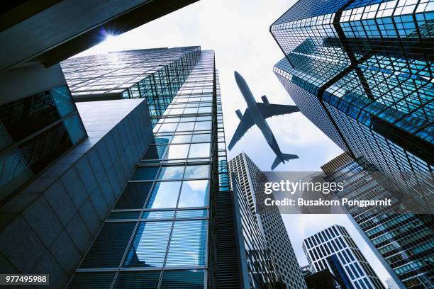 a plane flying over modern office buildings in central hong kong. - urban air vehicle stock pictures, royalty-free photos & images