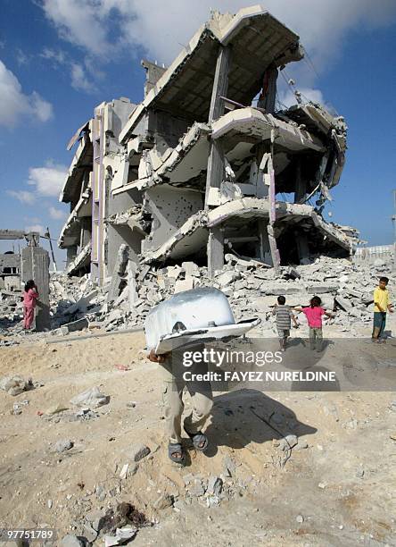 Palestinian children look at a four-storey building , dynamited by the Israeli army, in the Palestinian refugee camp of Khan Yunes in the south of...