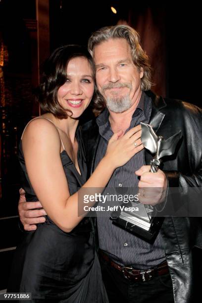 Actor Jeff Bridges hold his Best Male Lead award for 'Crazy Heart' with presenter Maggie Gyllenhaal backstage at the 25th Film Independent Spirit...