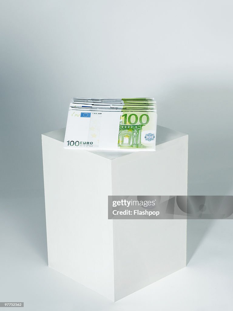 A pile of Euro notes on top of a plinth