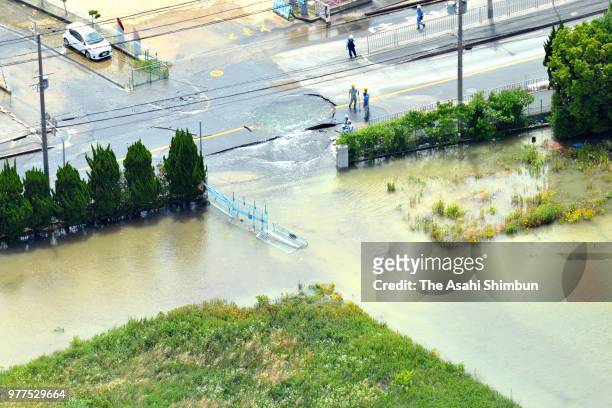 In this aerial image, water flowsfrom a crack on the road after the magnitude 6.1 strong earthquake on June 18, 2018 in Takatsuki, Osaka, Japan. A...