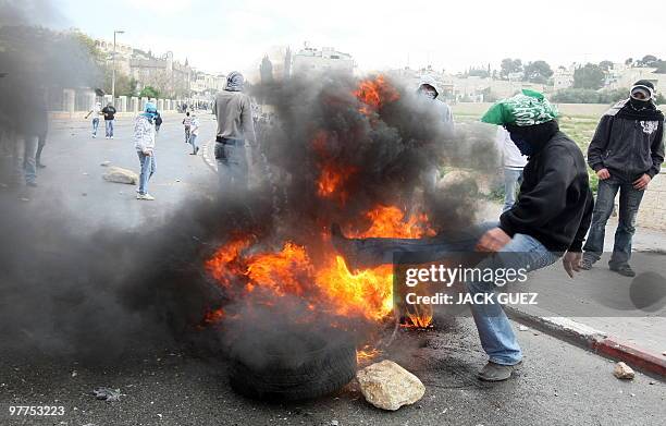 Palestinian demonstrator kicks a burning tyre during clashes with Isreli soldiers in east Jerusalem on March 16, 2010. Hundreds of Palestinians...