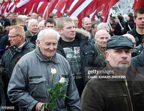 Veterans of the Latvian Legion, a force that was part of the Nazi German Waffen SS, walk with relatives to the Monument of Freedom as part of an...