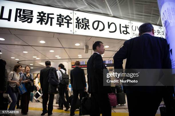 People are stranded in front of a ticket gate at Tokyo Station on June 18 after a suspending the operation of the Tokaido Shinkansen bullet train due...