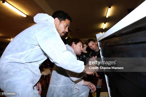 Te Toiroa Tahuriorangi and Matt Todd of the All Blacks help paint the Pirates Rugby Club's newly built pirate ship stage during an New Zealand All...