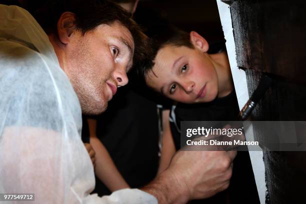 Matt Todd of the All Blacks helps paint the Pirates Rugby Club's newly built pirate ship stage during an New Zealand All Blacks community activity on...