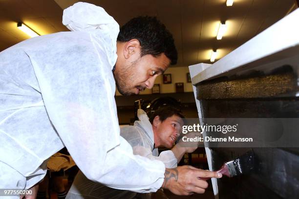 Te Toiroa Tahuriorangi and Matt Todd of the All Blacks help paint the Pirates Rugby Club's newly built pirate ship stage during an New Zealand All...