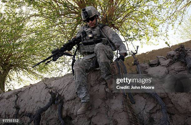 Army 1LT. Sgt. Jonathan Hendricks carries machine gun ammunition while under fire on March 16, 2010 at Howz-e-Madad in Kandahar province,...