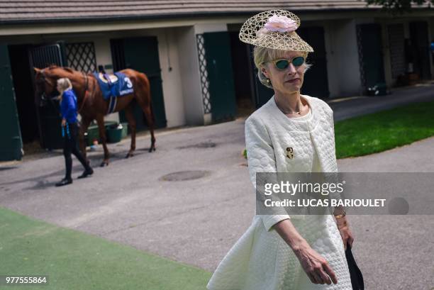 Woman walks around the stables during the 169thPrix de Diane horse racing on June 17, 2018 in Chantilly, northern Paris.