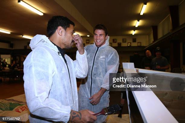 Te Toiroa Tahuriorangi and Matt Todd of the All Blacks share a laugh when painting the Pirates Rugby Club's newly built pirate ship stage during an...