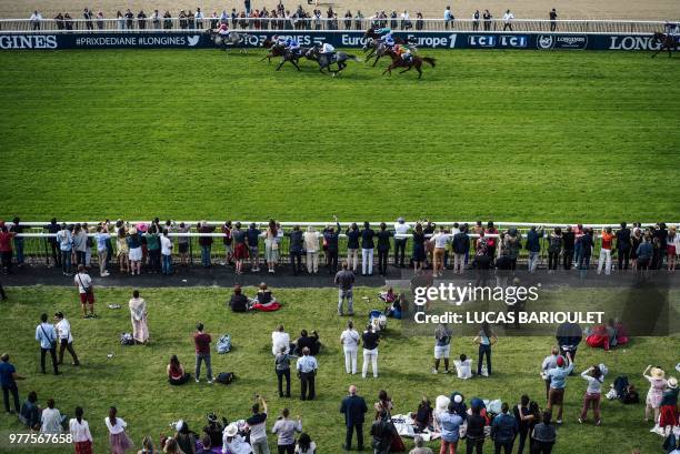 People watch the end of the 169th Prix de Diane horse racing on June 17, 2018 in Chantilly, northern Paris.