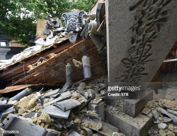 This picture shows a collapsed house following an earthquake in Ibaraki City, north of Osaka prefecture on June 18, 2018. At least two people,...