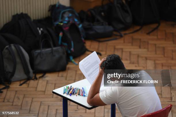 An high school student works on a 4 hours philosophy dissertation, that kicks off the French general baccalaureat exam for getting into university,...