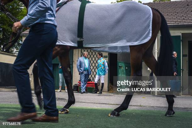 Jockey talks with a man at the stables during the 169th Prix de Diane horse racing on June 17, 2018 in Chantilly, northern Paris.