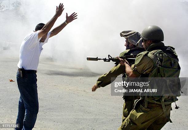 Palestinian Nabil Hamed, Bir Zeit University Coordinator for Yasser Arafat's Fatah al-Shabiba movement raises his hands while being threatened by...