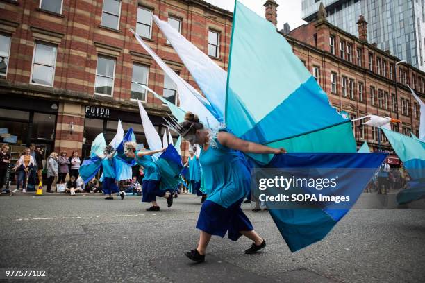 Women seen performing in colorful costumes during the Manchester day festival. Manchester Day is an annual event that celebrates everything great...