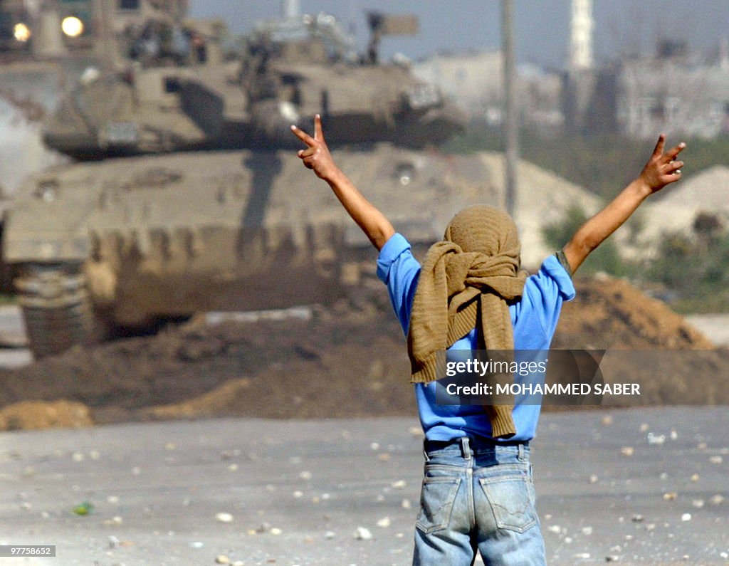 A Palestinian boy makes the 'V'-sign for