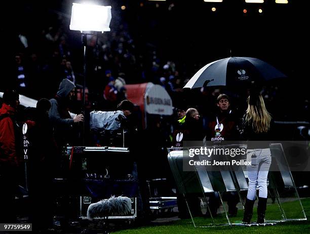 Women tv reporter is seen under a umbrella prior to the UEFA Europa League round of 16 first leg match between Hamburger SV and RSC Anderlecht at HSH...
