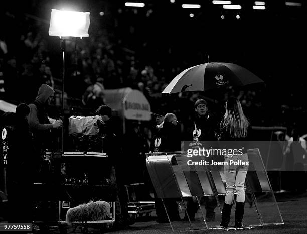 Women tv reporter is seen under a umbrella prior to the UEFA Europa League round of 16 first leg match between Hamburger SV and RSC Anderlecht at HSH...
