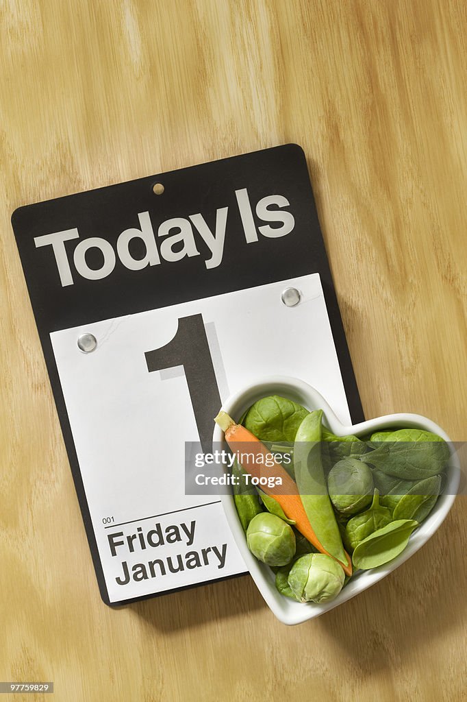 Heart shaped bowl of veggies and calender 