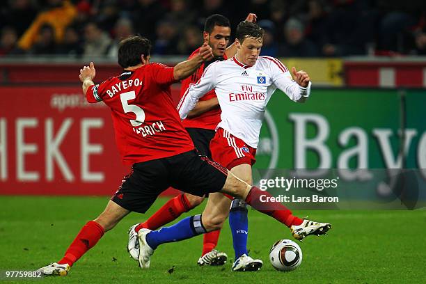 Manuel Friedrich and Renato Augusto of Leverkusen challenge Marcell Jansen of Hamburg during the Bundesliga match between Bayer Leverkusen and...