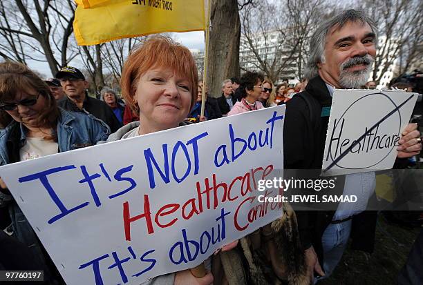 Participants display placards during a demonstration organized by the American Grass Roots Coalition and the Tea Party Express in Washington, DC, on...