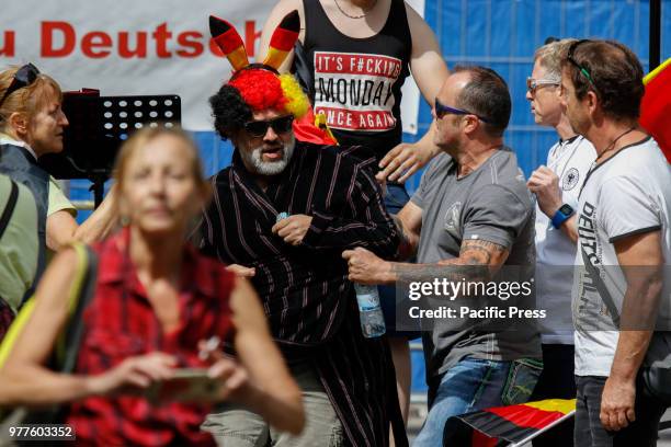 Counter protester wearing a wig in the German colours and a bathrobe is removed by stewards of the right-wing protest. Around 50 right-wing...