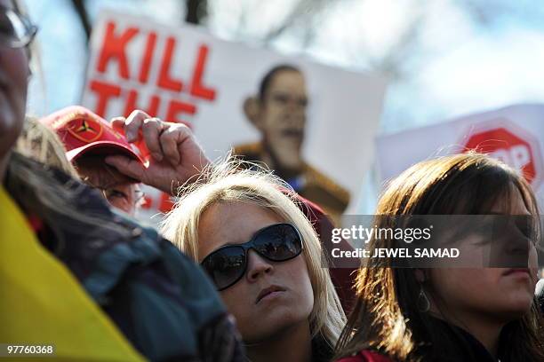 Participants display placards during a demonstration organized by the American Grass Roots Coalition and the Tea Party Express in Washington, DC, on...