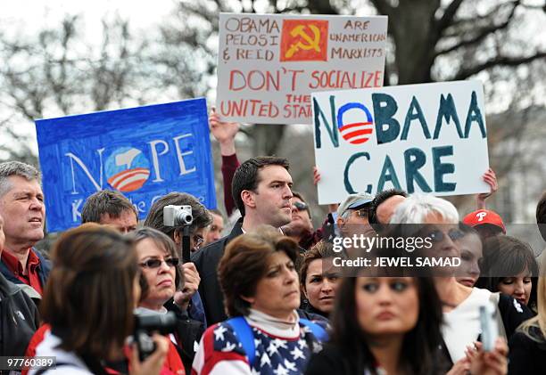 Participants display placards during a demonstration organized by the American Grass Roots Coalition and the Tea Party Express in Washington, DC, on...