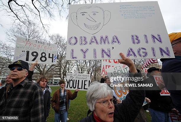 Participants display placards during a demonstration organized by the American Grass Roots Coalition and the Tea Party Express in Washington, DC, on...