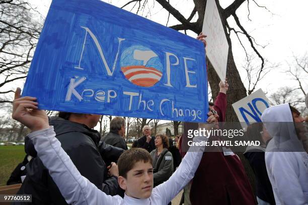Participants display placards during a demonstration organized by the American Grass Roots Coalition and the Tea Party Express in Washington, DC, on...