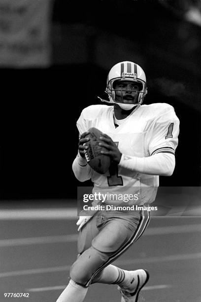 Quarterback Warren Moon of the Houston Oilers scrambles with the ball prior to throwing a pass during a game December 23, 1990 against the Cincinnati...