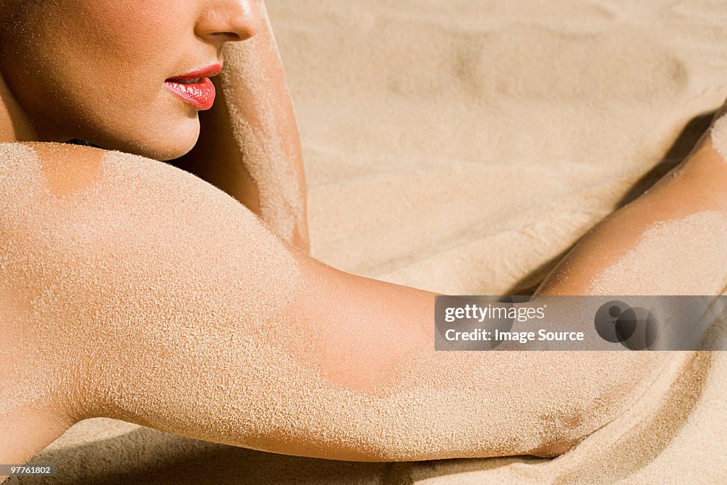 Woman with sand on her skin