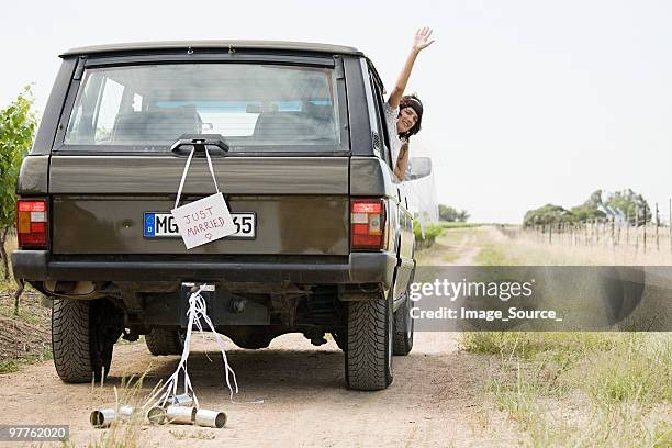newlywed woman waving from vehicle - just married car stock pictures, royalty-free photos & images
