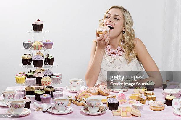 woman indulging in doughnuts and cakes - large group of objects stock pictures, royalty-free photos & images
