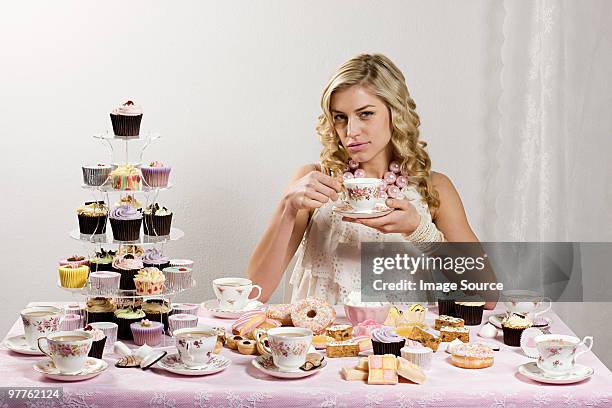 frau mit tisch, tee und kuchen - cupcake teacup stock-fotos und bilder