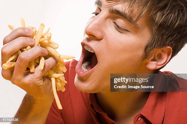 man with handful of fries - french fries bildbanksfoton och bilder