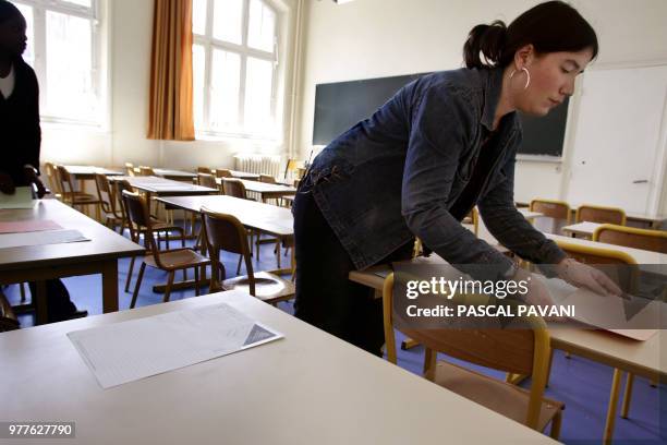 Des personnes distribuent des feuilles d'examen dans une classe du lycée Racine, le 08 juin 2005 à Paris. La session du baccalauréat démarre le 09...