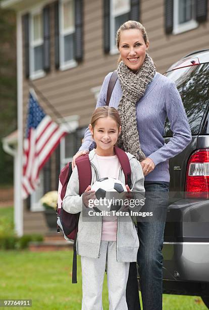 mother and daughter holding soccer ball - soccer mum stock-fotos und bilder